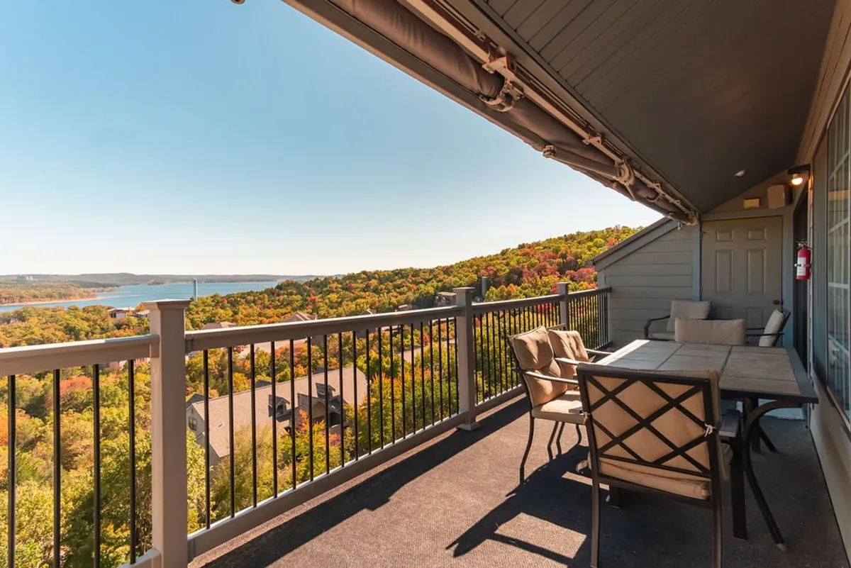 The image highlights an outdoor seating area with a view of the surrounding landscape, including a railing that hints at an elevated balcony. The serene setting suggests a perfect spot for morning coffee or evening relaxation after a day at the theme park.