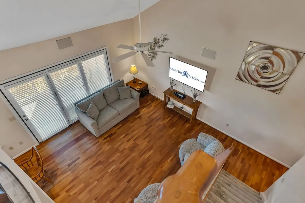 A cozy upstairs living nook outfitted with a sofa, television, and a warm lamp, suggesting a perfect spot for intimate conversations, late-night chats, or movie marathons. The soft lighting and arrangement create a relaxed, welcoming vibe for smaller groups or quiet moments.